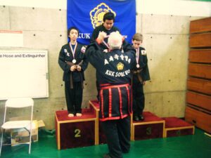 Master giving medal to student